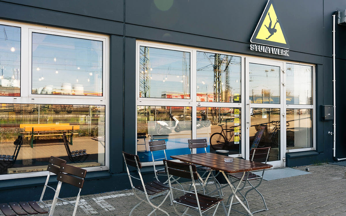 Außenbereich des Stuntwerk Köln Zollstocks mit Bistrotischen zum Verweilen