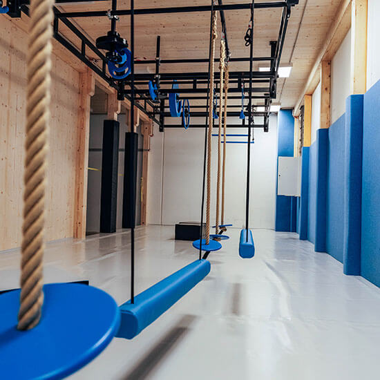 Blick in den Ninja-Bereich des Stuntwerks mit blauen Hindernissen, Seilen und Hang-Elementen an der Decke
