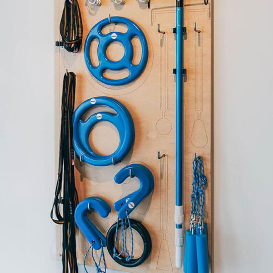 Verschiedene Ninja-Obstacles, wie Ringe, Griffe oder Stange, die an einer Holzwand hängen. Bereit dafür, zum Training genutzt zu werden.