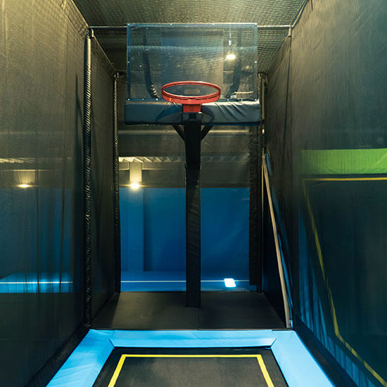 Trampolin-Basketballanlage im Stuntwerk mit integrierter Sprungfläche, Basketballkorb und gepolsterten Seitenwänden für sicheres Springen und Werfen.