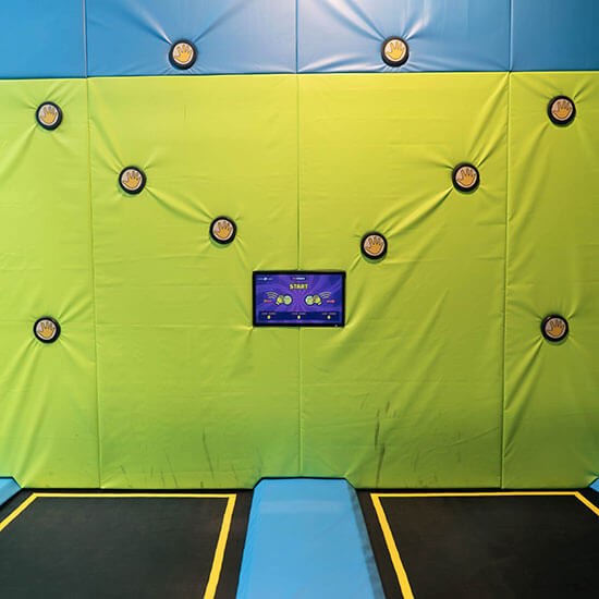 Interaktives Trampolin-Reaktionsspiel im Stuntwerk mit beleuchteter Zielwand, Touch-Sensoren und digitalem Bildschirm zur Punkteanzeige.