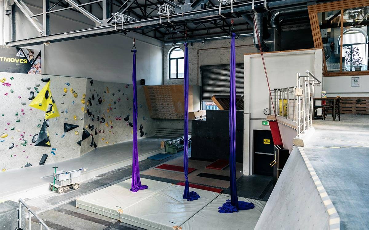 Vertikaltuchbereich mit Tüchern und Matten vor der Boulderwand.